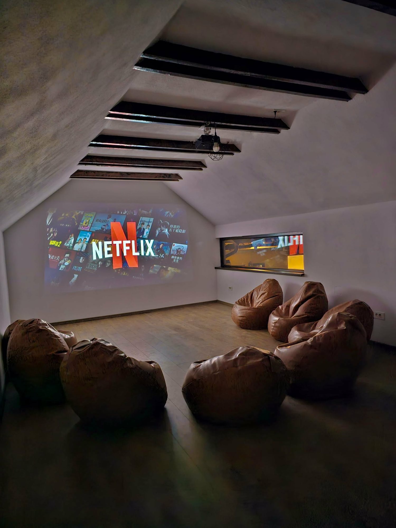 Mini sală de cinema cu proiector și fotolii puf